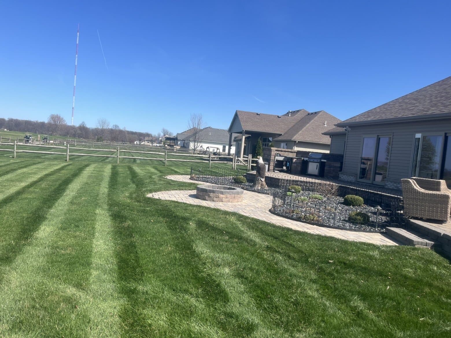 Professionally striped Clean Edge lawn beside a finished patio